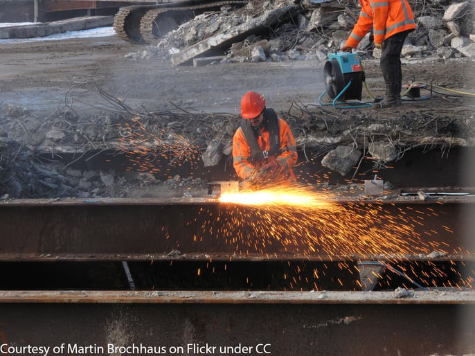 A construction worker cutting steel